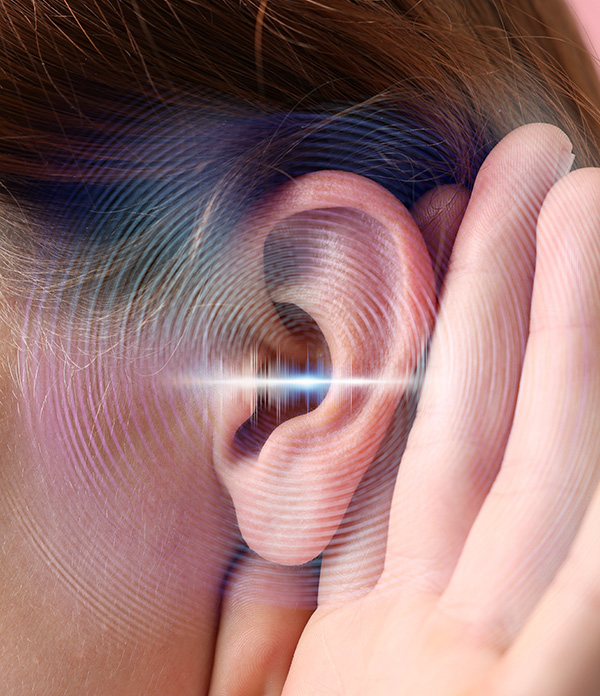 A person holds a hand up to their ear, suggesting they are trying to listen closely. Digitally illustrated sound waves around the ear symbolize hearing or perception of sound, highlighting the importance of hearing services.